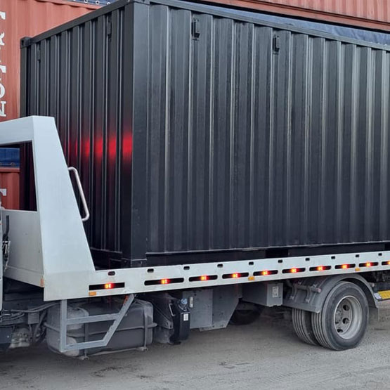 Black shipping container loaded on a delivery truck for sale in Brisbane QLD